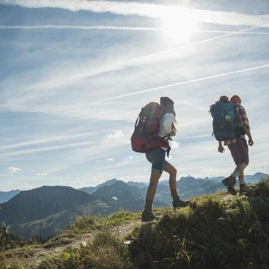 Austria, Tyrol, Tannheimer Tal, young couple hiking on mountain trail