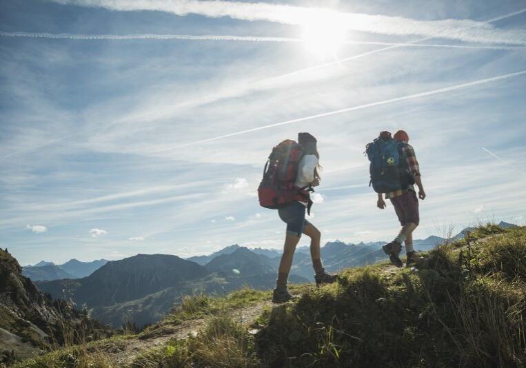 Austria, Tyrol, Tannheimer Tal, young couple hiking on mountain trail
